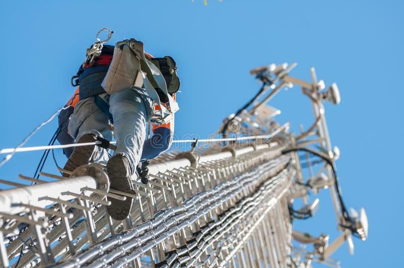 Worker clipping a harness lanyard to a guard rail